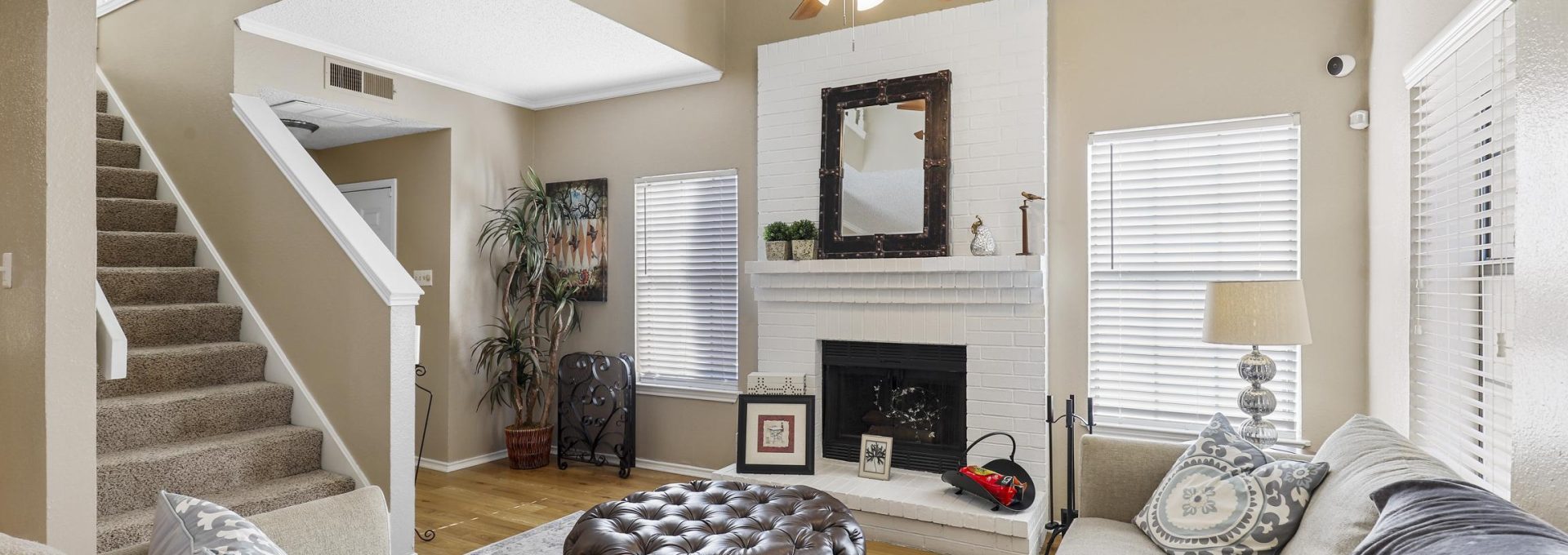 a living room with a fireplace and stairs at The Waterchase Gardens