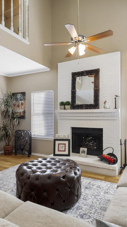 a living room with a fireplace and stairs at The Waterchase Gardens