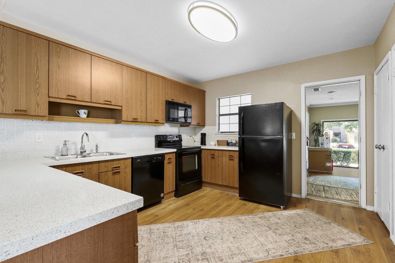 a kitchen with black appliances and wood cabinets at The Waterchase Gardens